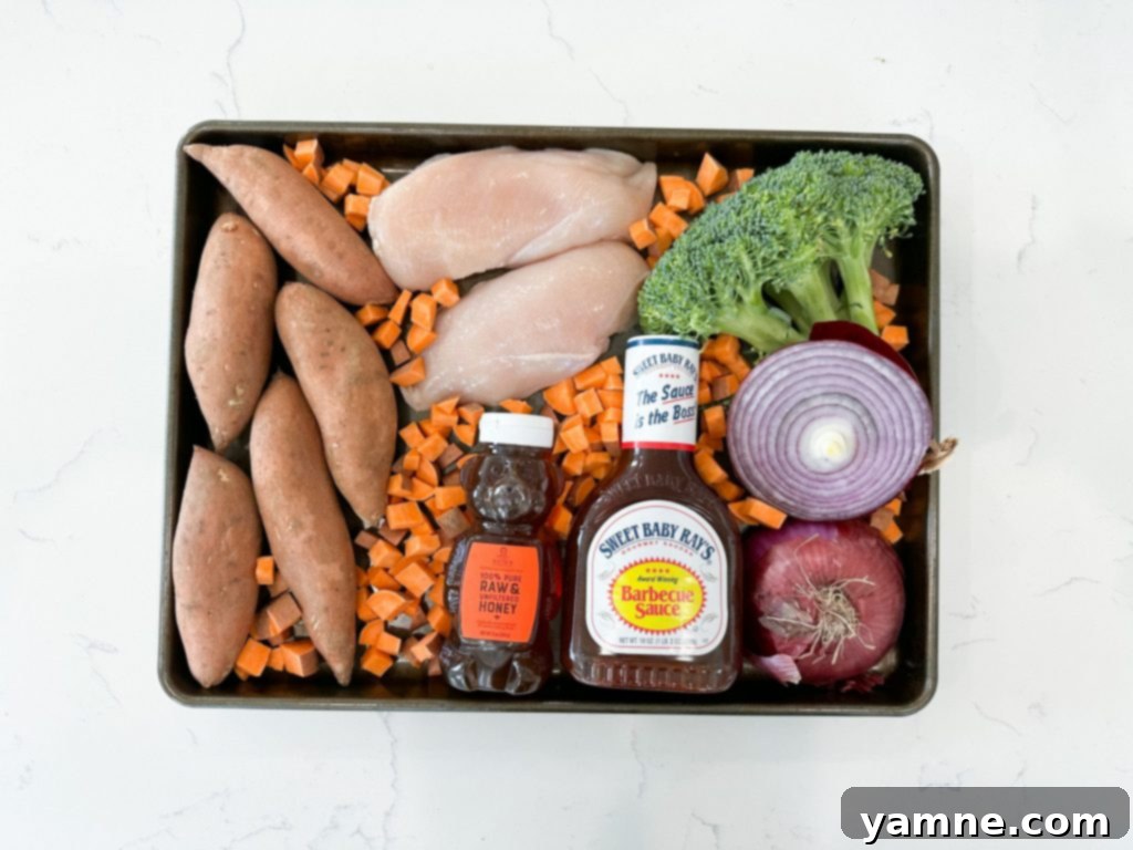 Sheet Pan BBQ Chicken and Vegetables with sweet potatoes and broccoli, ready to be baked for a delicious, healthy dinner.