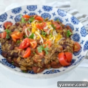 A close-up of a serving of Easy Red Beans and Rice with sausage slices in a rustic bowl, ready to be enjoyed.