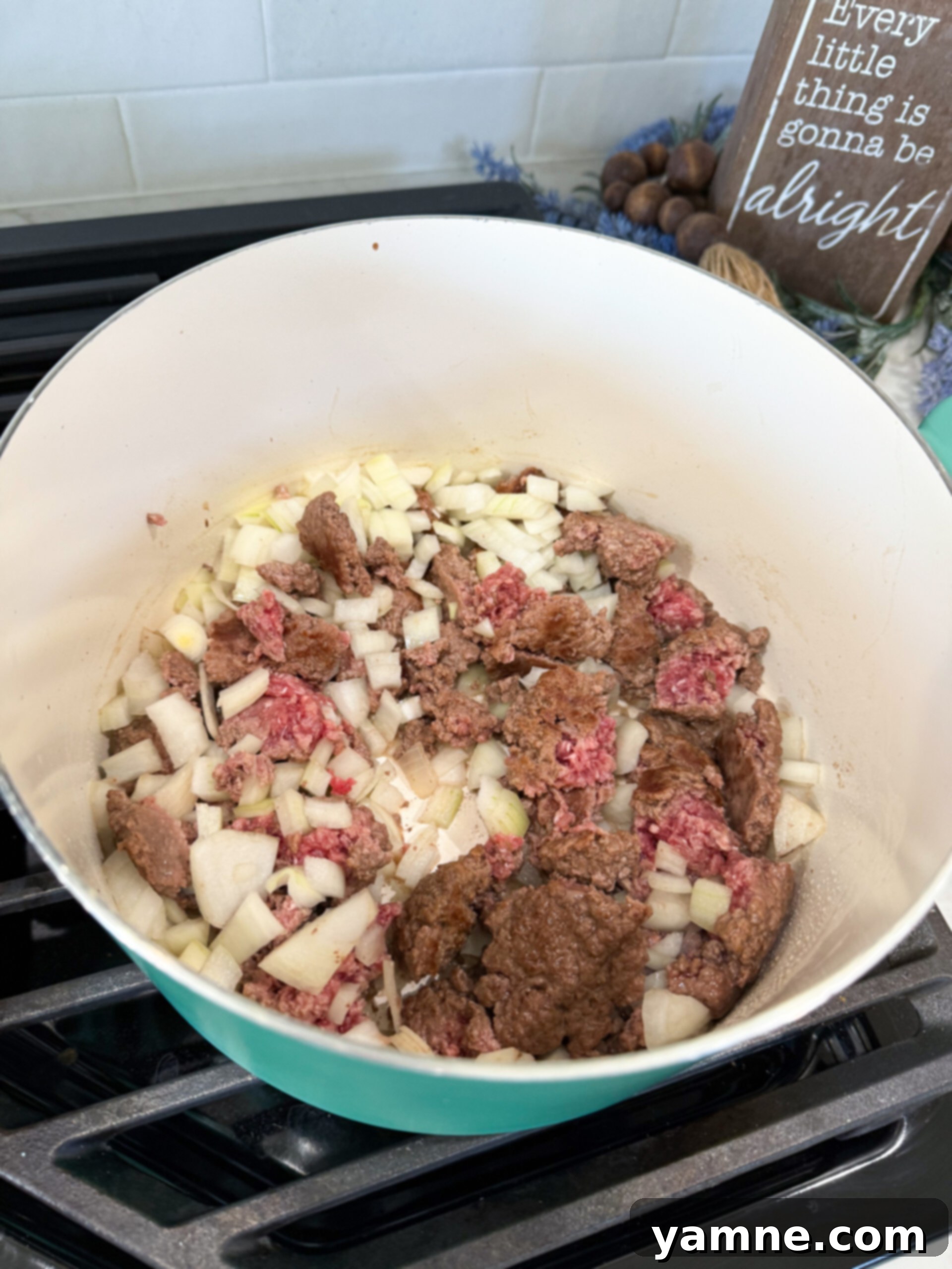 Ground beef cooking and browning in a large pot, an essential first step for building deep savory flavor in the vegetable soup.