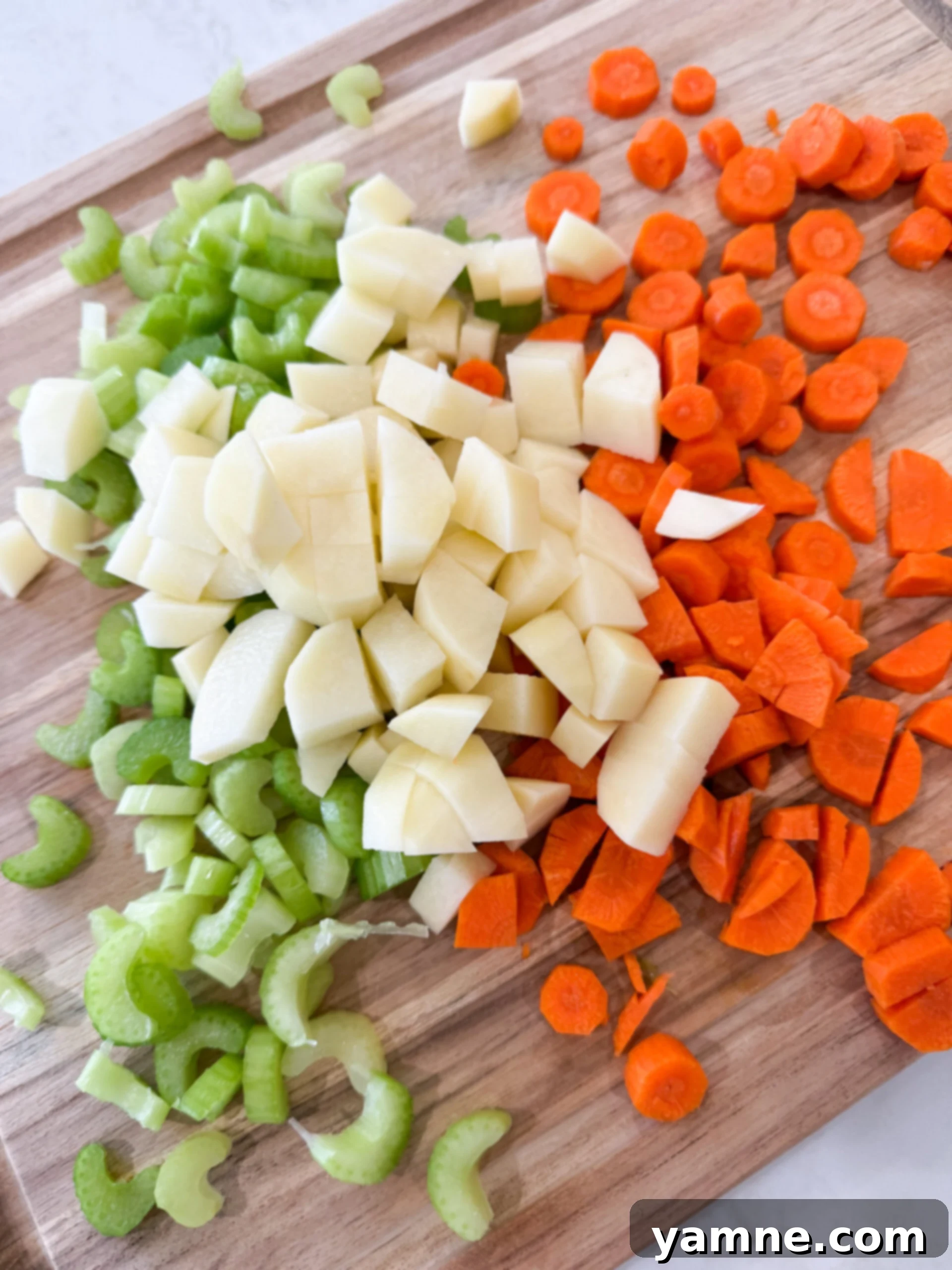 Freshly chopped potatoes, celery, and carrots neatly prepared and ready for adding to the ground beef and vegetable soup pot.