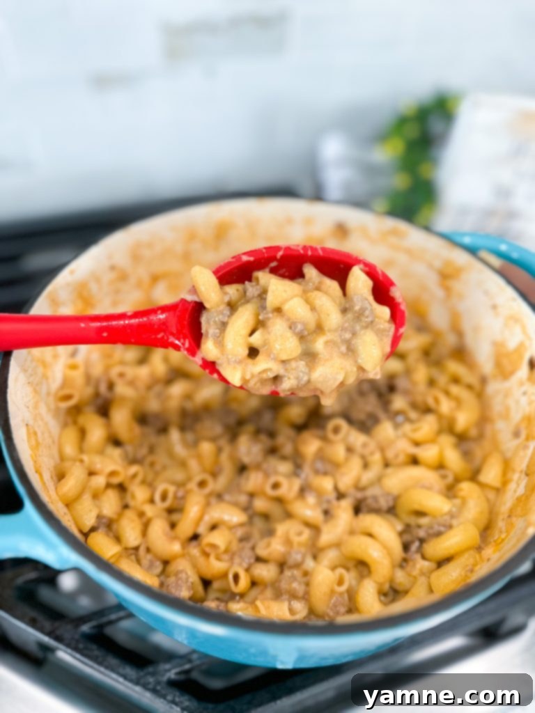 Close-up of ingredients for Cheeseburger Pasta laid out on a wooden board
