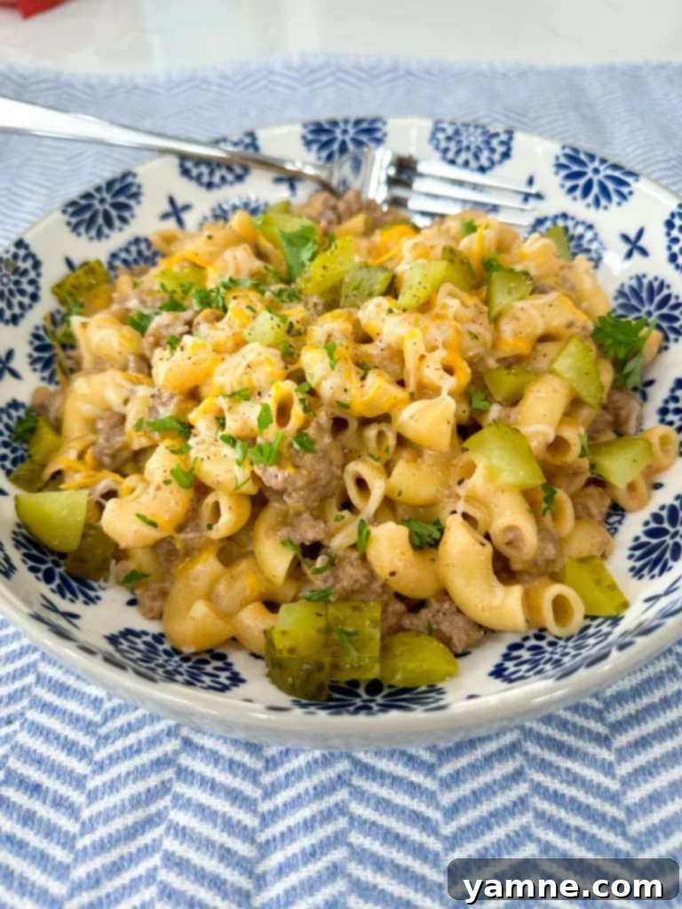 A serving of finished Cheeseburger Pasta with pickles on top