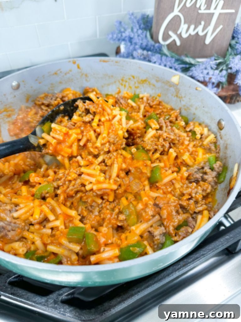 Close-up of bubbling Macaroni and Cheese Pizza Casserole with visible pepperoni and melted cheese