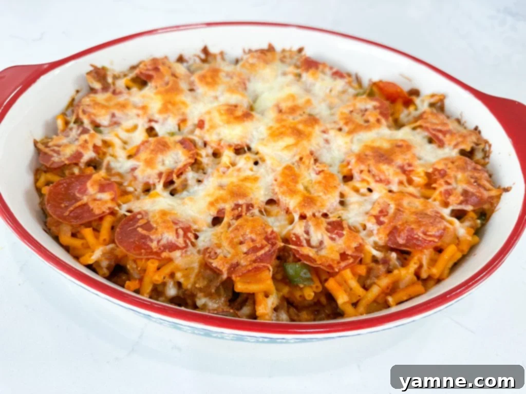 A perfectly portioned slice of Macaroni and Cheese Pizza Casserole on a white plate