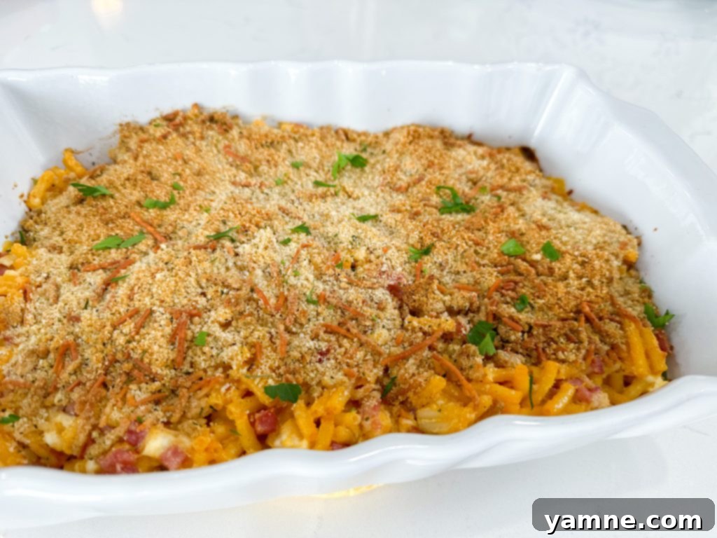 Cheesy Ham Macaroni Bake 4 A dish of Cheesy Ham Macaroni and Cheese Casserole with a spoon