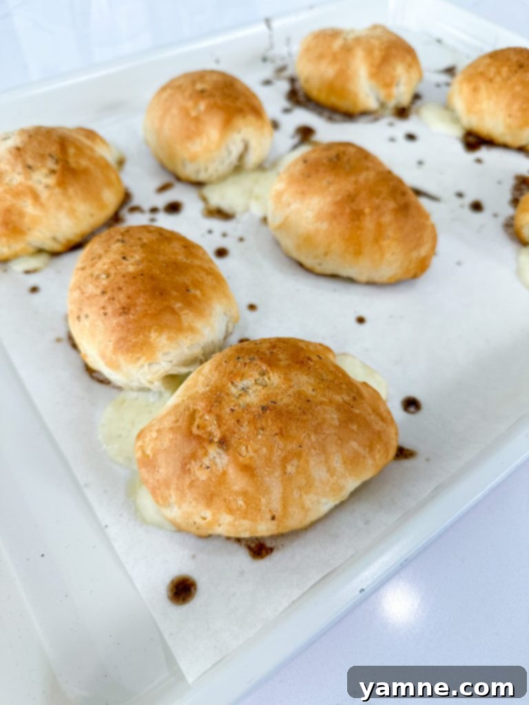 Stuffed Ham and Cheese Biscuits brushed with seasoning and ready for the oven.