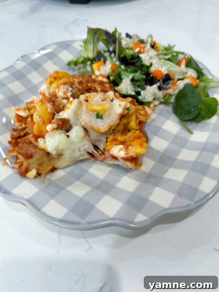 Effortless Slow Cooker Sausage Tortellini Lasagna 8 A serving of Slow Cooker Sausage Tortellini Lasagna in a bowl, showing the layers of pasta, sauce, and cheese, ready to be eaten.