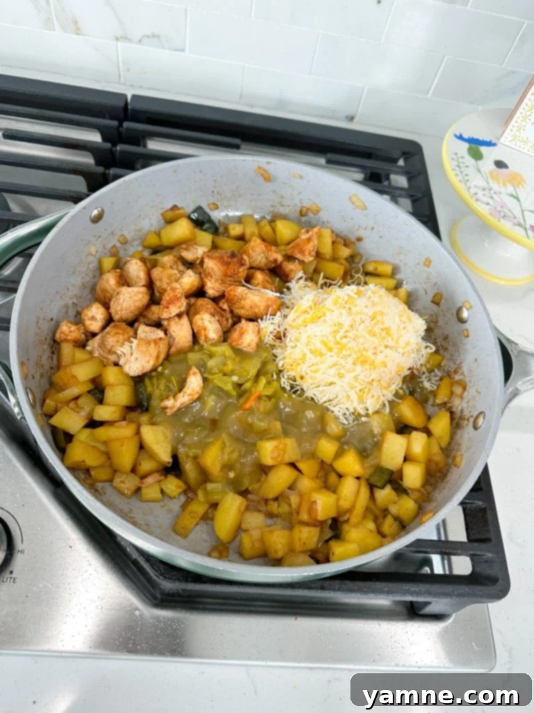 Sautéed onions and poblano peppers cooking in a skillet