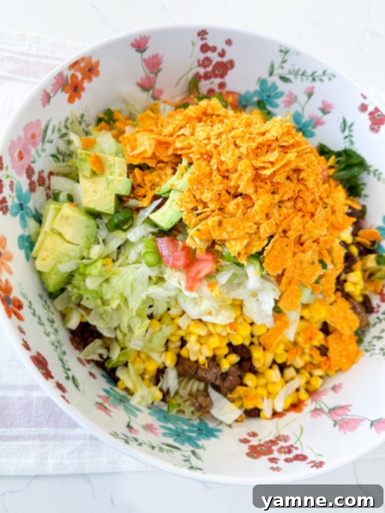 Close-up of the fresh ingredients prepped for Doritos Taco Pasta Salad, including diced tomatoes, green onions, and avocado.