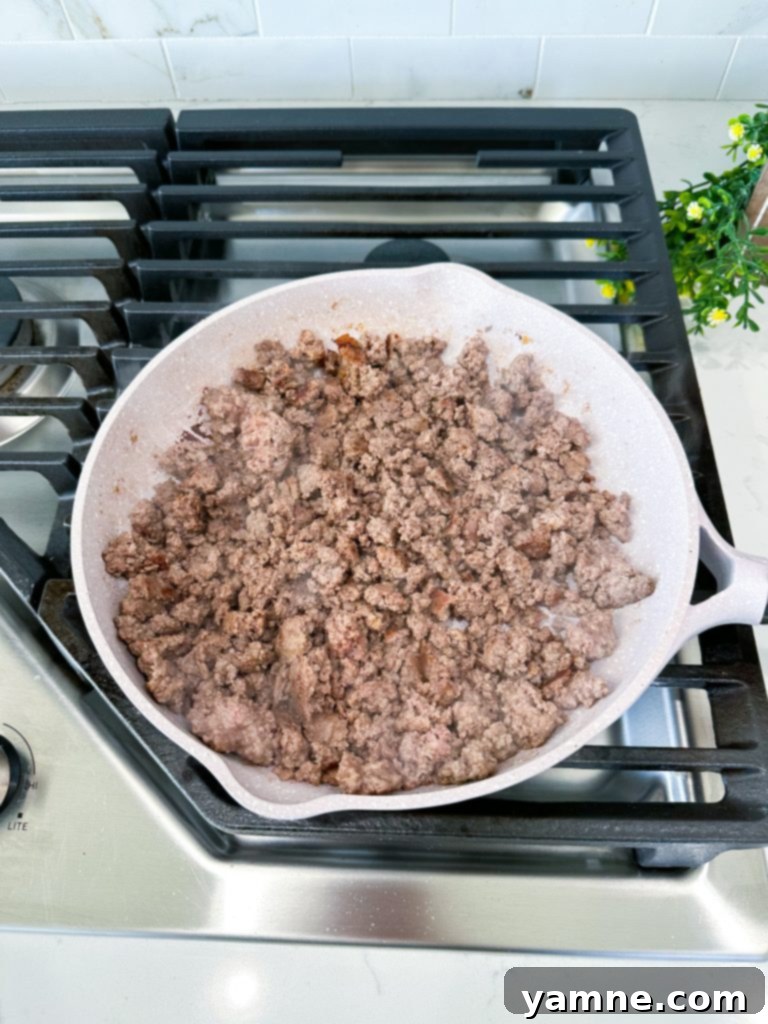 Doritos Taco Bake 3 Cooking ground beef in a skillet for taco pie filling