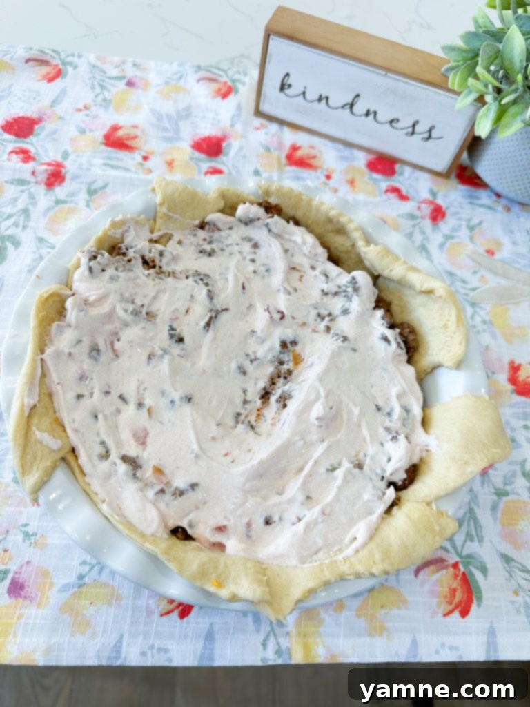 Doritos Taco Bake 6 Crushed Doritos sprinkled over crescent dough in a pie dish