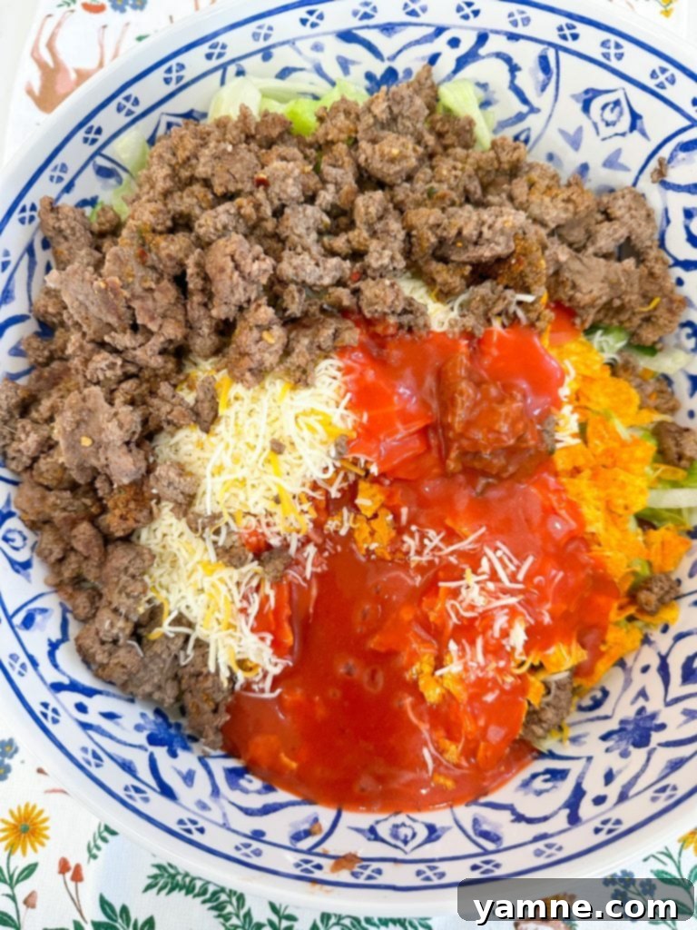 Crunchy Doritos Taco Salad 5 Mixing taco salad ingredients in a large bowl