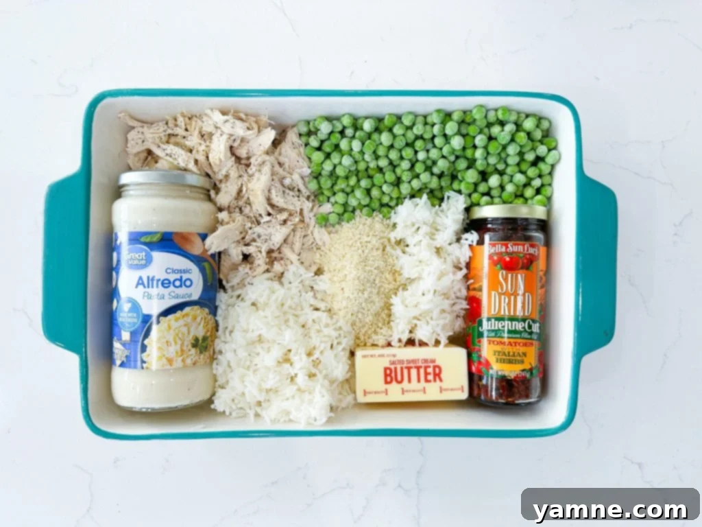 Creamy Chicken Alfredo Rice Casserole with a golden Panko topping, green peas, and sun-dried tomatoes