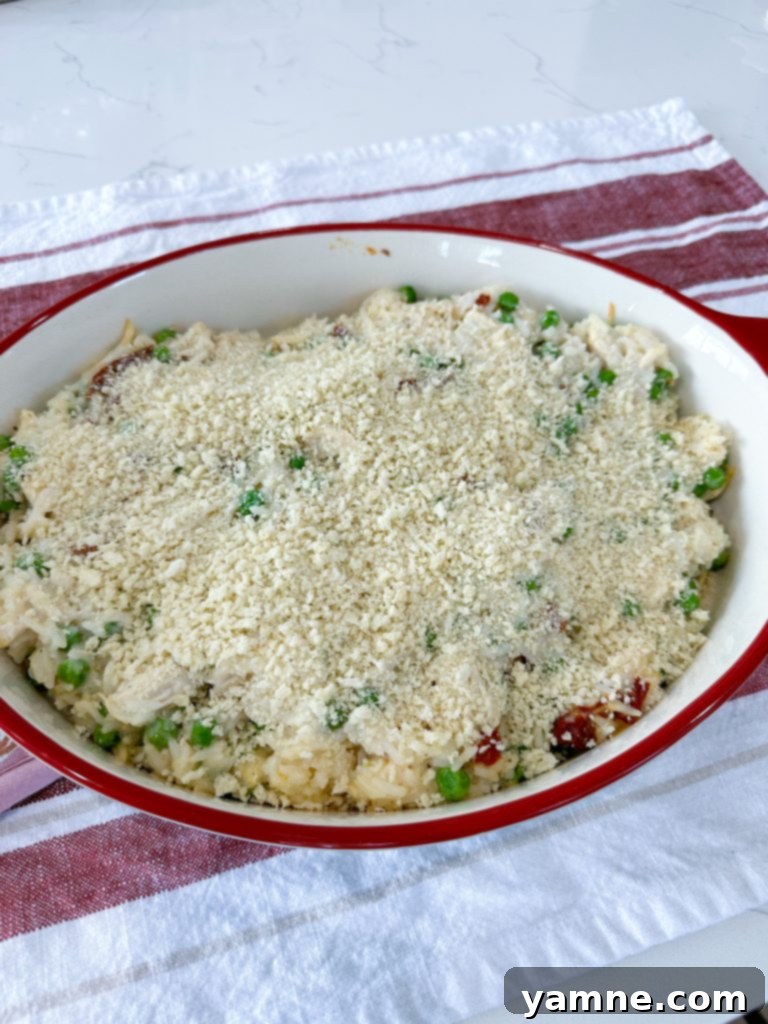 Sprinkling Panko breadcrumbs over the partially baked casserole.