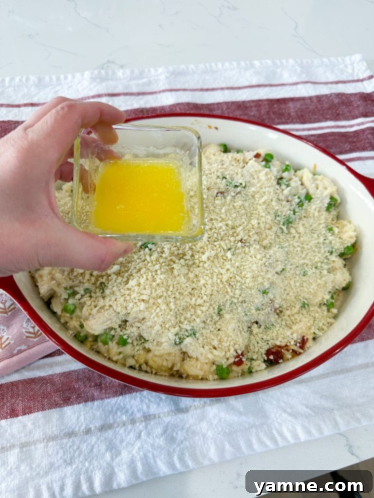 Drizzling melted butter over the Panko topping.