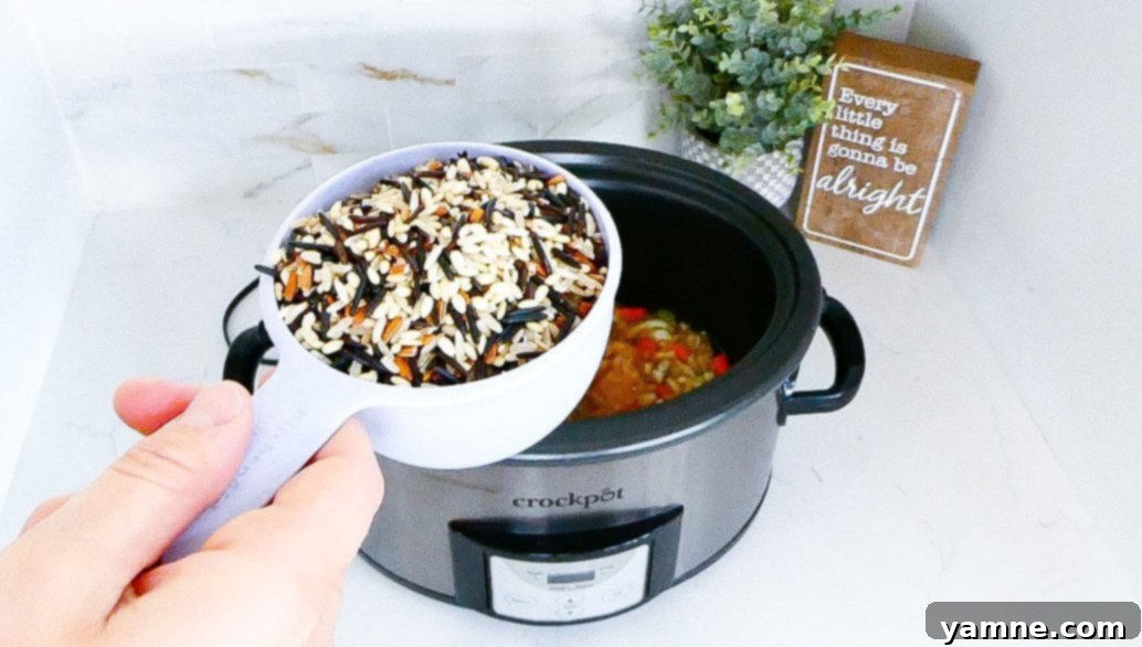 The Slow Cooker Chicken and Wild Rice cooking, with the lid slightly ajar, demonstrating the cooking process and internal temperature check.