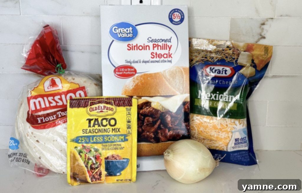 All the fresh ingredients for making steak fajita quesadillas, including steak, bell peppers, onions, and cheese