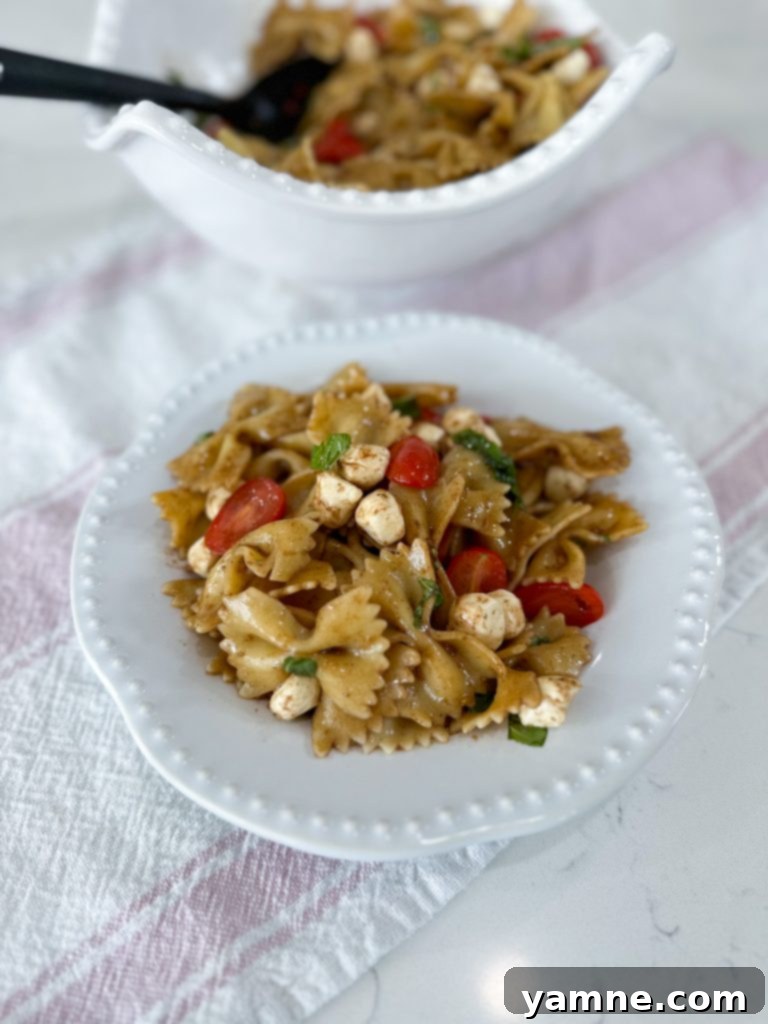 A large bowl of Caprese Pasta Salad, ready for serving at a summer gathering.