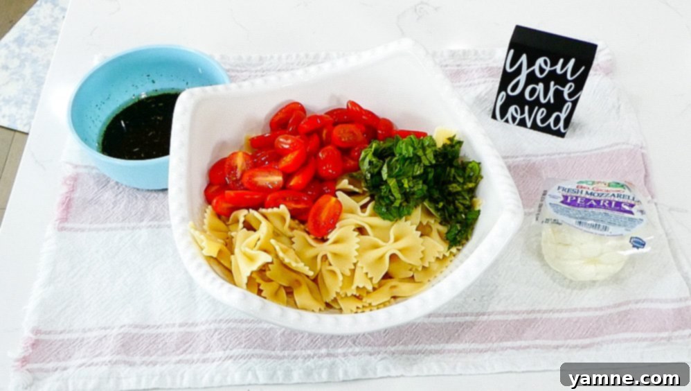 Pouring the balsamic vinaigrette over the pasta salad ingredients.