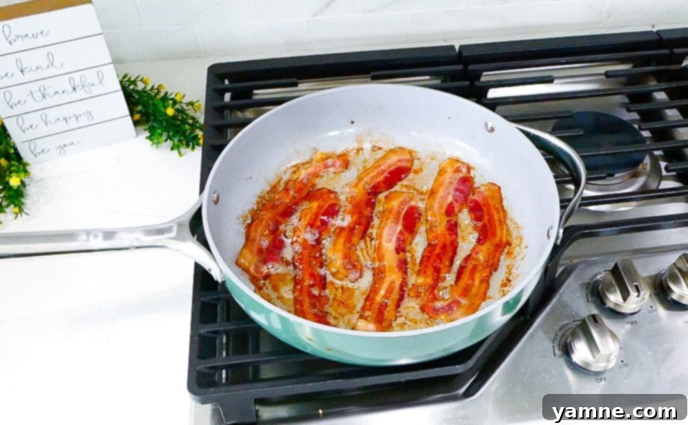 Tuscan Ranch Pasta Salad 3 Cooked rotini pasta being rinsed under cold water in an over-the-sink strainer.