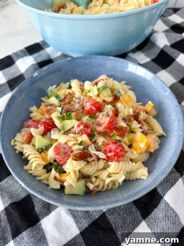 Tuscan Ranch Pasta Salad 8 All pasta salad ingredients being mixed in a large bowl.