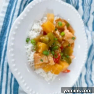 Delicious Slow Cooker Sweet and Sour Chicken served over white rice with fresh herbs.