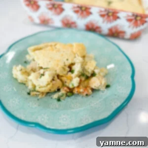 Delicious Chicken Cobbler with a golden biscuit topping, served hot in a baking dish.