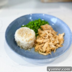 Slow Cooker Honey Chicken served over rice, garnished with green onions.