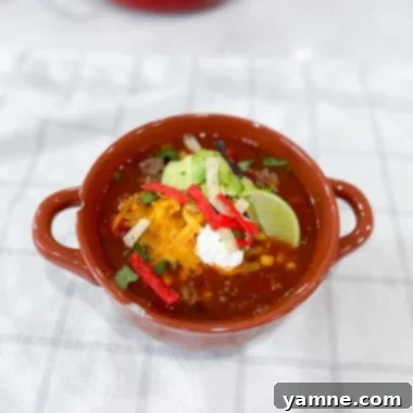 A vibrant bowl of one-pot taco soup garnished with fresh cilantro and a dollop of sour cream, ready to be enjoyed.
