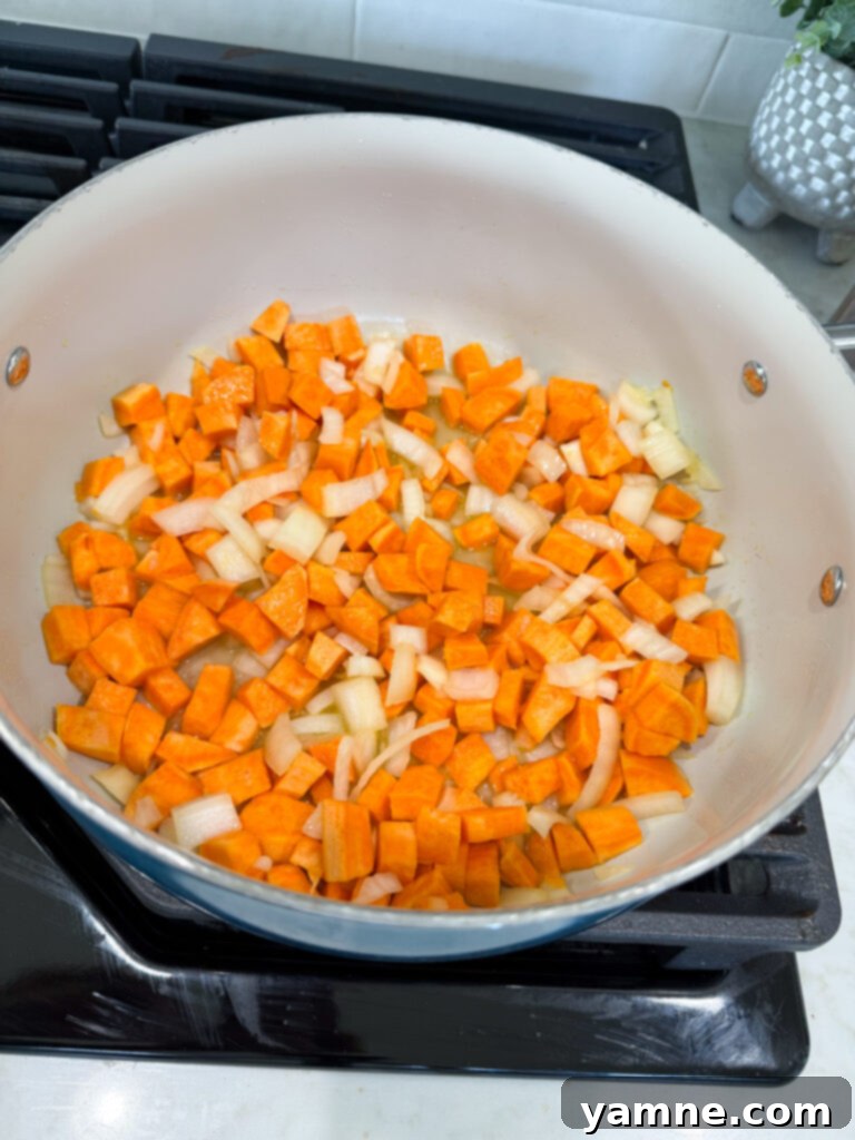Stirring sweet potato mixture with chicken broth