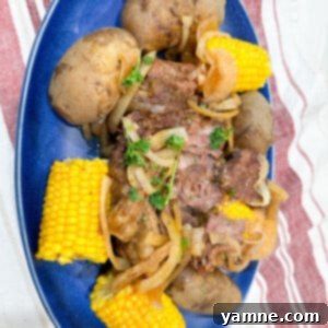 Hearty Slow Cooker Pot Roast with roasted potatoes and corn on the cob, a perfect family meal.