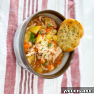 Rustic Tuscan Chicken and Potato Stew 2 A bowl of rich and creamy Tuscan Chicken and Potato Stew, garnished with fresh herbs.