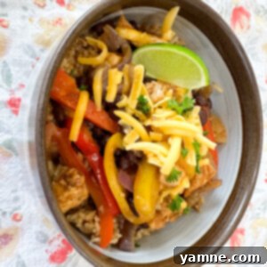 Vibrant chicken fajita bowl with seasoned chicken, colorful bell peppers, and fresh toppings served over a bed of fluffy taco rice.