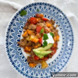 A deliciously cooked Beef and Potato Skillet topped with melted cheese and fresh herbs, ready to serve.