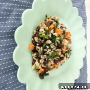 A vibrant Sweet Potato Black Bean Skillet, garnished and ready to serve, showcasing tender sweet potatoes, dark black beans, and hints of green spinach.