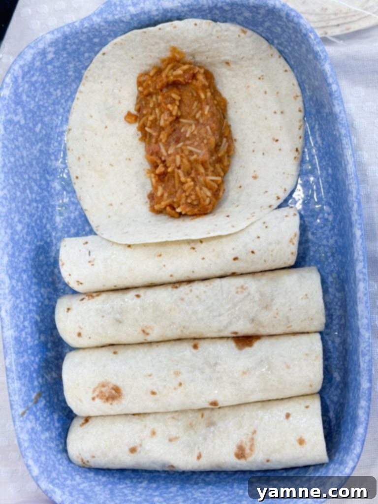 Filling tortillas for bean and rice enchiladas