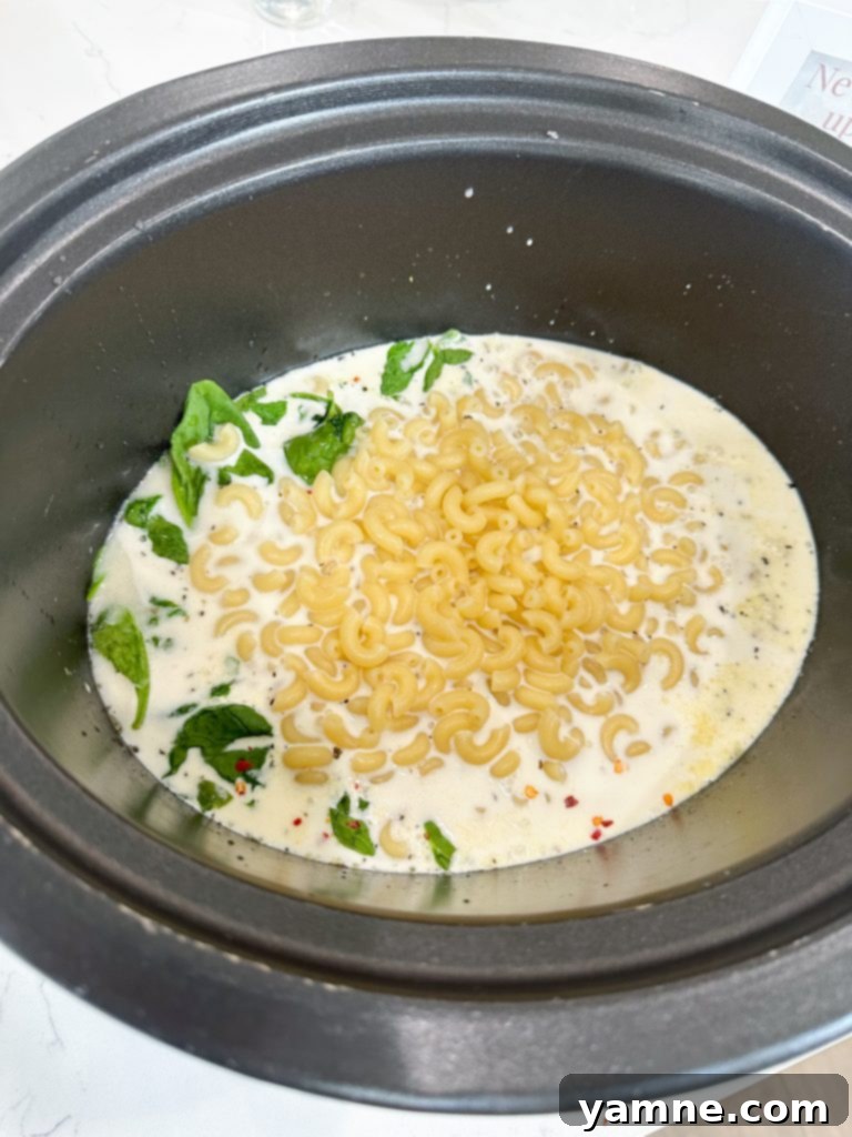 Adding Ingredients to Slow Cooker Italian Chicken Noodle Soup