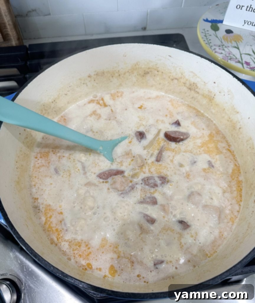 Sautéing chicken and kielbasa for Cajun Alfredo