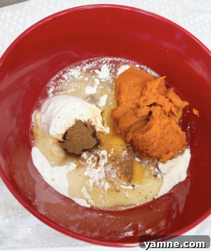Spiced Pumpkin Honey Bun Cake 3 Mixing the pumpkin honey bun cake batter in a large bowl.