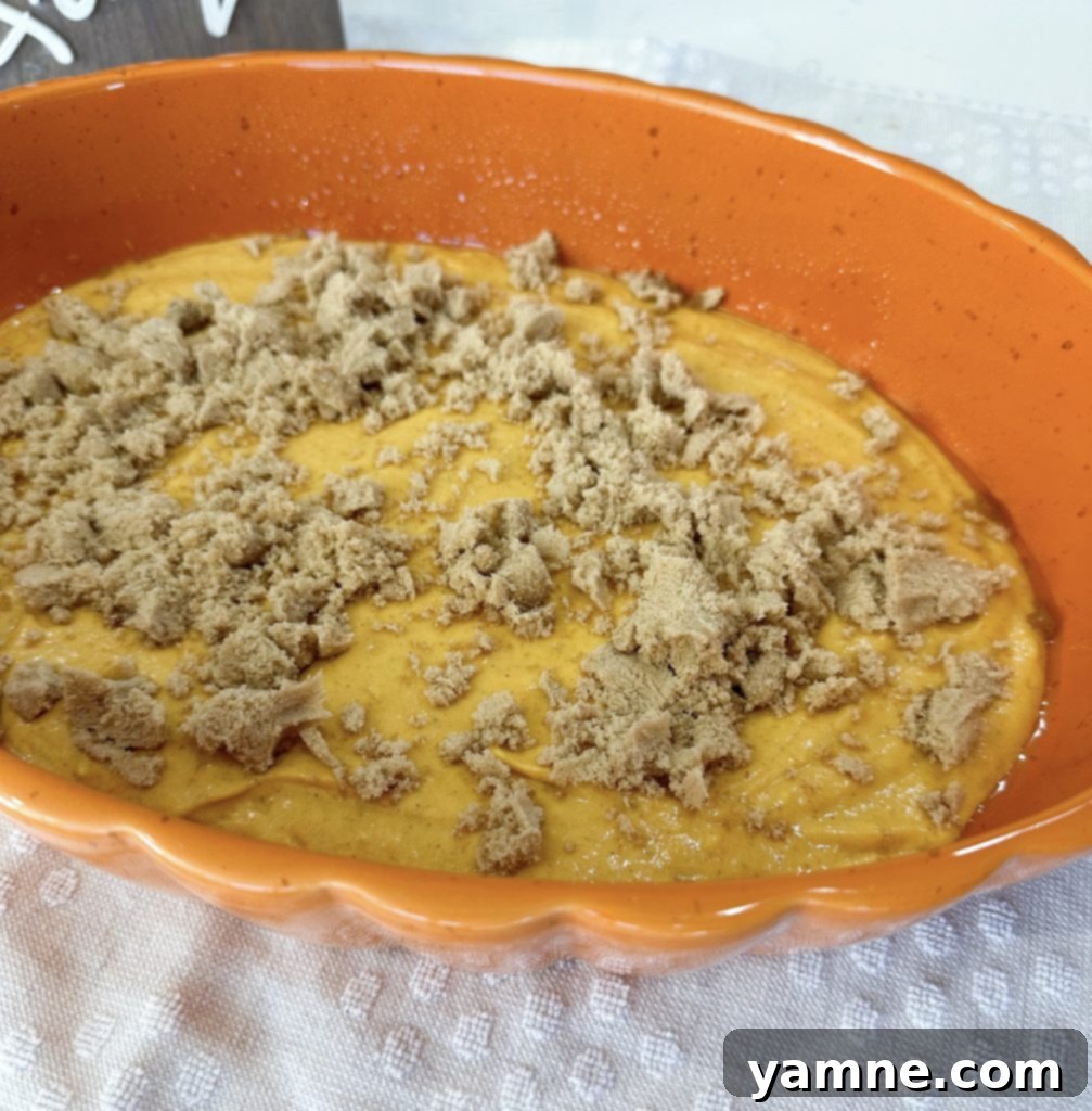 Spiced Pumpkin Honey Bun Cake 5 First layer of pumpkin cake batter spread in a baking dish.