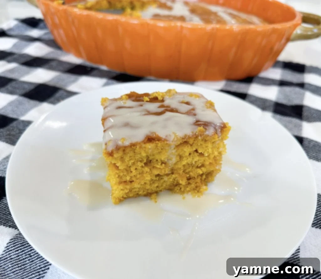 Spiced Pumpkin Honey Bun Cake 9 A slice of Pumpkin Honey Bun Cake on a white plate, showcasing the layers.