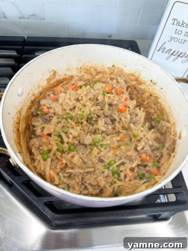 Loaded Cheeseburger Hash Brown Bake 3 cheeseburger hashbrown casserole cooking in a skillet