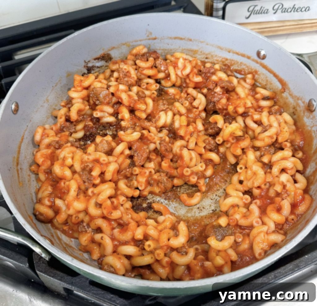 Mixing sloppy joe ingredients with macaroni and cheese