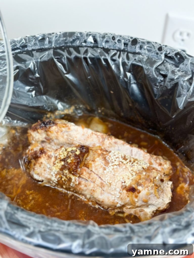 Sliced slow cooker pork tenderloin in an airtight container for leftovers