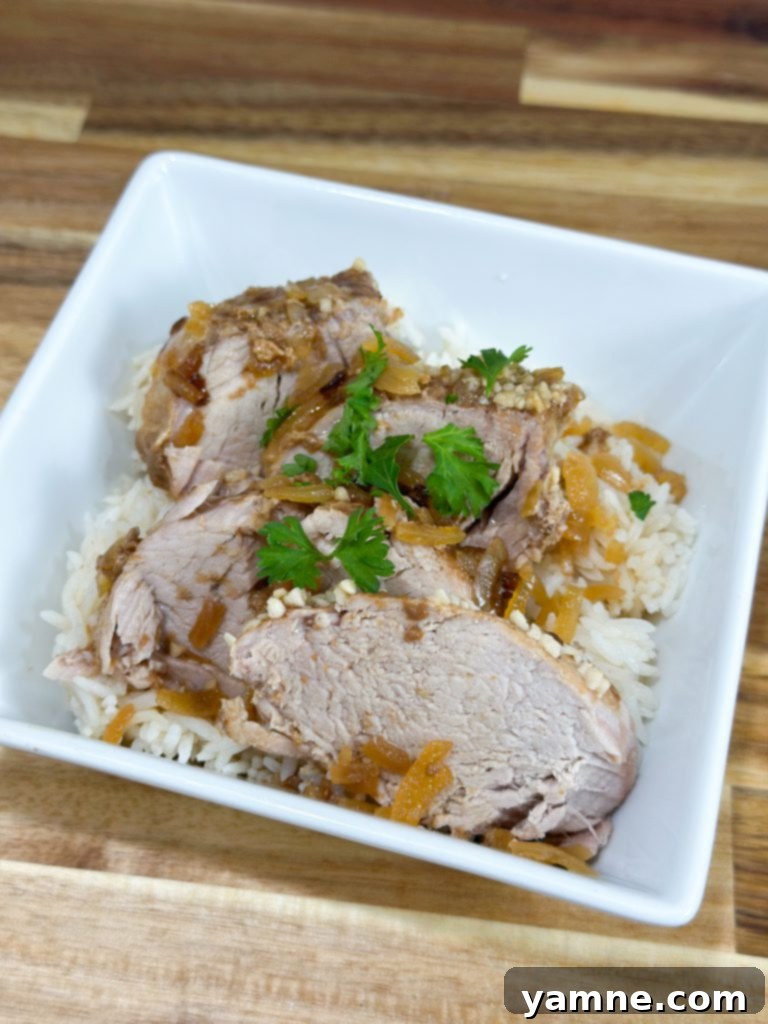 Delicious slow cooker pork tenderloin sliced and served with a side of rice