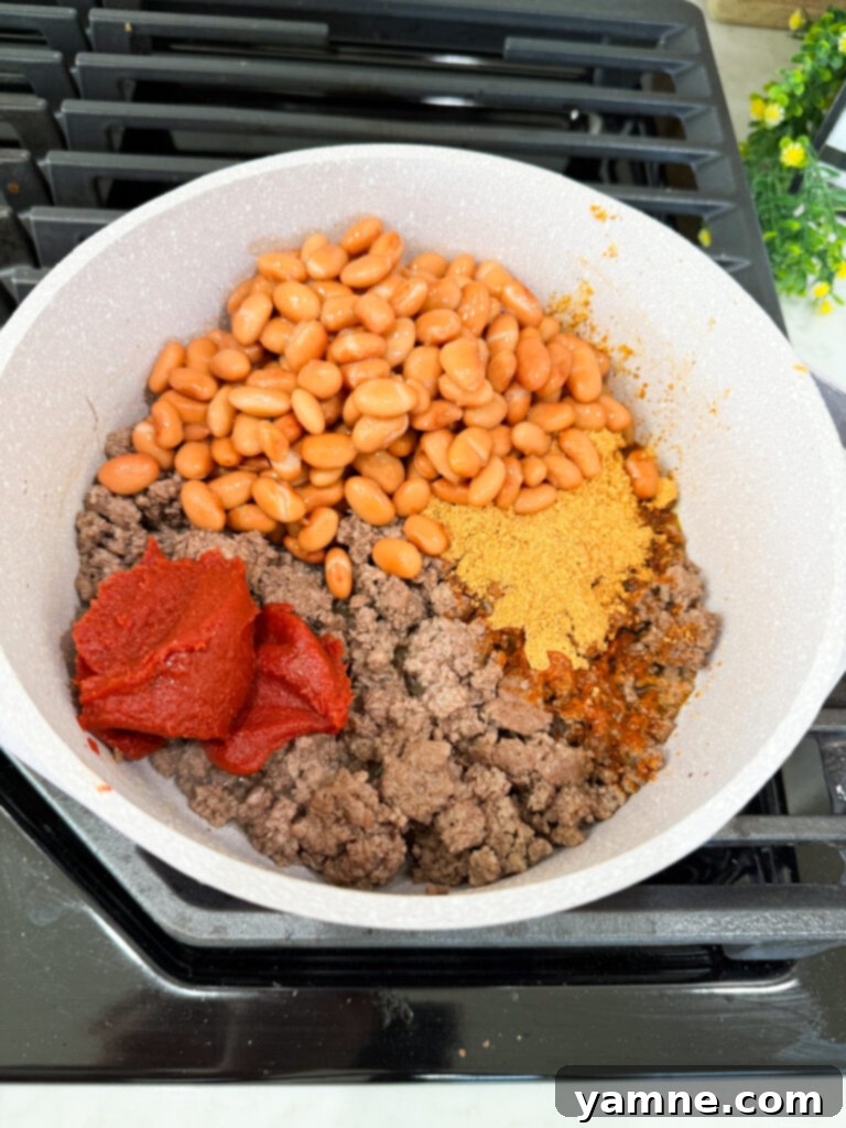 add beans and tomato paste to meat
