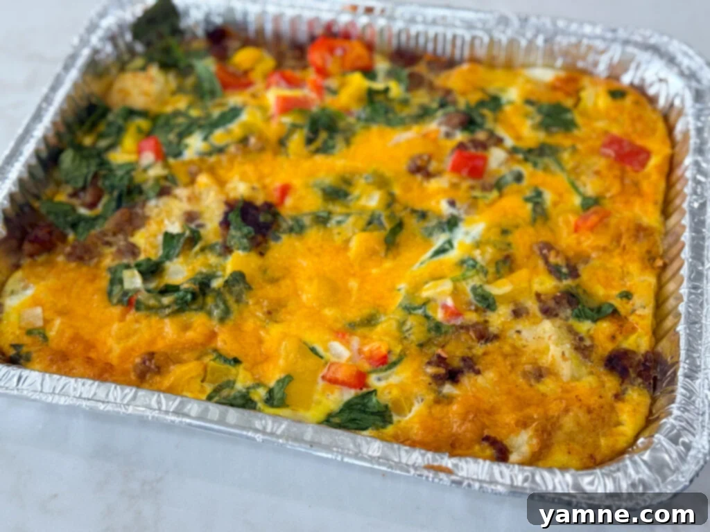 Sausage Hash Brown and Egg Casserole siting in a tin foil casserole dish.