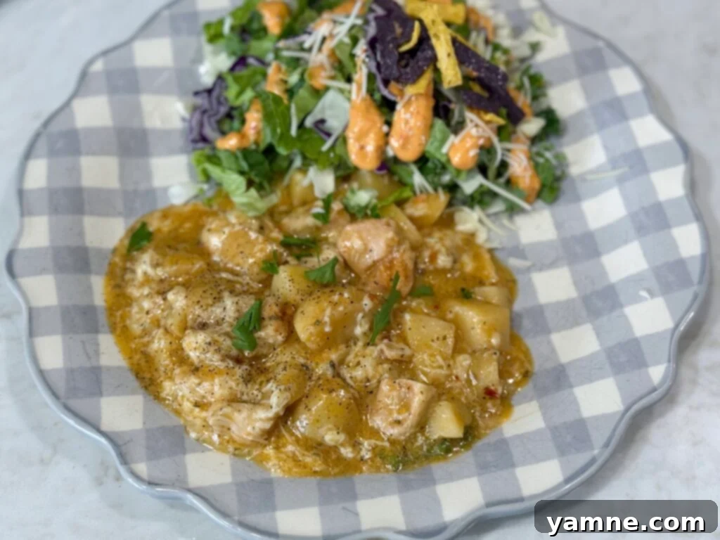 Comforting Slow Cooker Garlic Parmesan Chicken and Potatoes 2 chicken and potatoes on a blue and white plate with salad