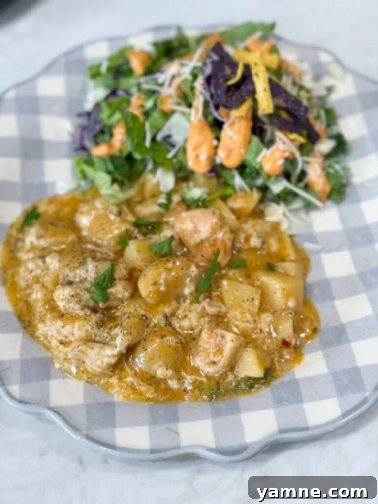 Comforting Slow Cooker Garlic Parmesan Chicken and Potatoes 11 chicken and potatoes on a blue and white plate with salad