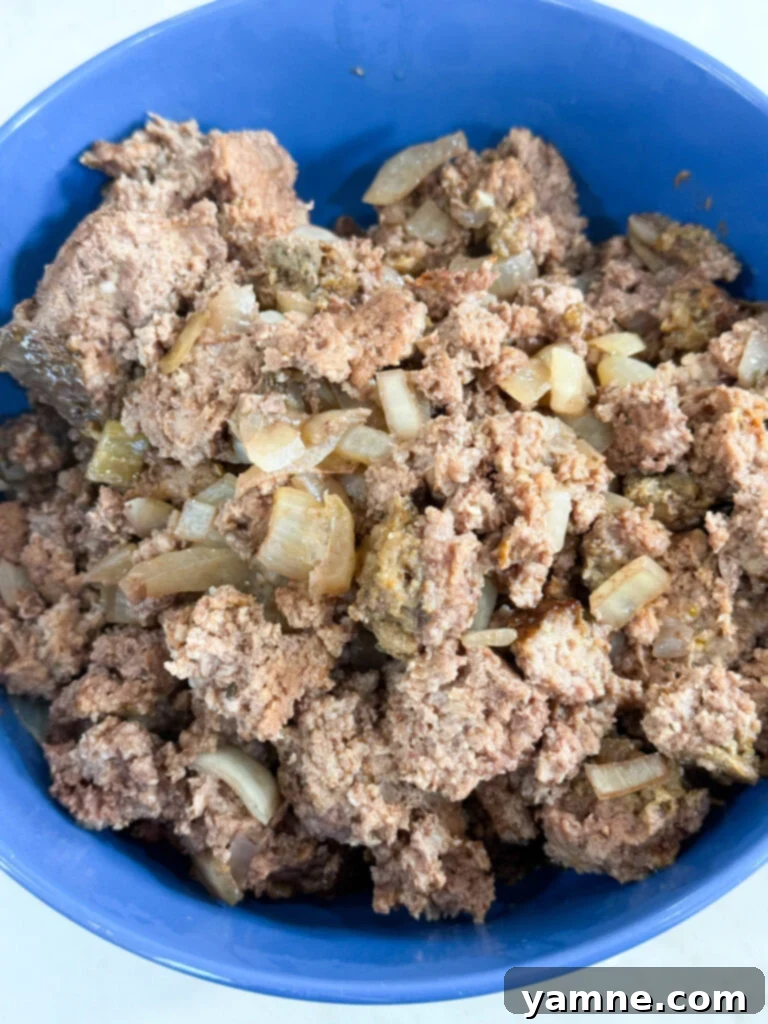 Cooked ground beef and onions in a blue bowl, showcasing a versatile and flavorful slow cooker recipe perfect for easy meals.